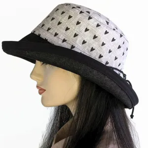 Sunblocker UV sun hat with wide brim, featuring black hearts on grey with black denim brim